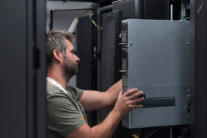Técnico instalando nobreak corporativo em rack de infraestrutura empresarial